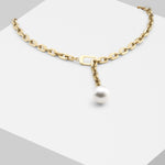 Die LIEBESKIND BERLIN Halskette - The Short Pearl von Liebeskind Berlin präsentiert eine einzelne weiße Perle in moderner Goldoptik aus Edelstahl, elegant auf weißem Podest - die perfekte zarte Perlenkette für stilvolle Akzente.