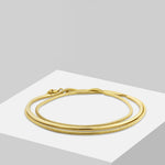 Liebeskind Berlin Armband bestehend aus einem goldenem Armreif und einer goldenen Schlangenkette im Layeringstyle; Produktbild