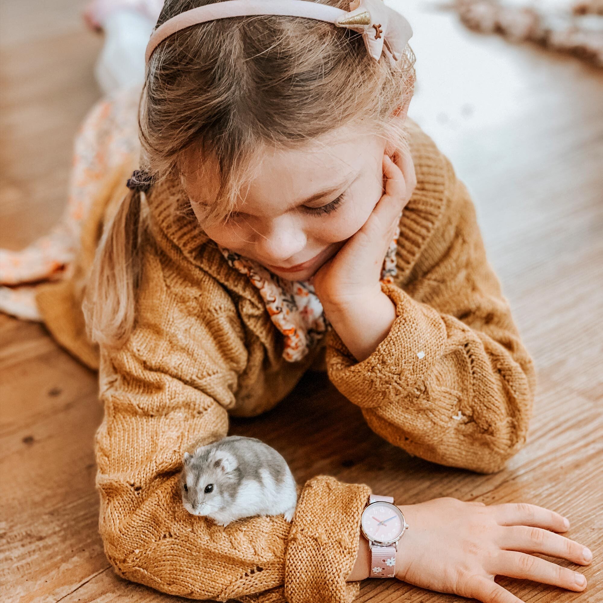 Cool Time Kids Armbanduhr mit rosa Zifferblatt, silbernem Gehäuse und rosa Textilarmband mit weißen Blumen; Tragebild