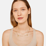 Liebeskind Berlin Halskette bestehend aus einer goldenen Venezianerkette und acht kleinen, runden Edelstahlplättchen; Tragebild