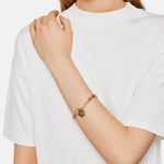 Liebeskind Berlin Armband bestehend aus einer groben, goldenen Gliederkette und zwei goldenen Anhängern; Tragebild