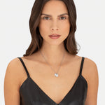 Liebeskind Berlin Halskette bestehend aus einer filigranen, silbernen Kette mit einem kleinen Herzanhänger und zwei gravierten, runden Plättchenanhängern; Tragebild