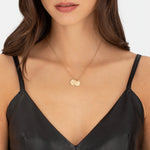 Liebeskind Berlin Halskette bestehend aus einer filigranen, goldenen Kette mit einem kleinen Herzanhänger und zwei gravierten, runden Plättchenanhängern; Tragebild