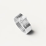 Der PDPaola Ring - Layered Rings in 52 von PDPaola besteht aus mehreren dünnen Silberbändern mit einem kleinen Cluster aus klaren Edelsteinen, die sich elegant vor einem weißen Hintergrund abheben.