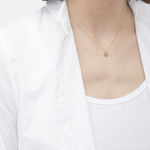 Liebeskind Berlin Halskette bestehend aus einer roségoldenen Ankerkette und einem roségoldenem, runden Anhänger mit Logoaufdruck und Zirkoniastein; Tragebild