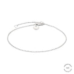 Das LIEBESKIND BERLIN Armband aus der Gold Collection von Liebeskind Berlin besticht durch sein filigranes Design mit einem kleinen runden Anhänger und einem Verschluss auf weißem Grund.