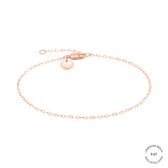 Das Liebeskind Berlin Armband - Gold Collection besteht aus einer zarten Kette aus 18 Karat Roségold mit einem kleinen, kreisförmigen, gravierten Anhänger und einem Karabinerverschluss auf weißem Hintergrund. Der Text "Gold Collection" erscheint unten rechts.