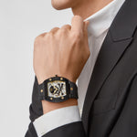 Ein Mann in schwarzem Anzug und weißem Hemd trägt eine Philipp Plein Armbanduhr - The Black $keleton von Philipp Plein an seinem linken Handgelenk.