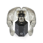 Die Philipp Plein Armbanduhr - The Black $keleton, eine luxuriöse Herrenuhr, präsentiert sich in einem facettierten, transparenten Totenkopfgehäuse auf einem marmorähnlichen Sockel.