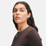 Frau mit gewellten dunklen Haaren in einem braunen Oberteil trägt bunte LIEBESKIND BERLIN Ohrhänger - Colorful Icon by Liebeskind Berlin vor einem hellen Hintergrund.