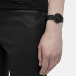 Liebeskind Berlin Armbanduhr mit schwarzem Zifferblatt, Datumsanzeige, weißen Indizes, schwarzem Gehäuse und schwarzem Edelstahlband; Tragebild