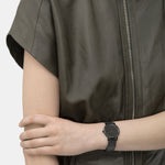 Liebeskind Berlin Armbanduhr mit grauem Zifferblatt, schwarzen Indizes, schwarzem Gehäuse und schwarzem, glitzerndem Meshband; Tragebild