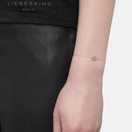 Liebeskind Berlin Armband bestehend aus einer filigranen, goldenen Kette mit einem Anhänger mit Logoaufdruck und einem zentrierten Zirkoniastein; Tragebild