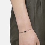 Liebeskind Berlin Armband bestehend aus einer filigranen, schwarzen Kette mit einem Anhänger mit Logoaufdruck und einem zentrierten Zirkoniastein; Tragebild