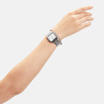 Ein erhobener Arm mit einer silbernen Armbanduhr und dem LIEBESKIND BERLIN Armband - The Basic Trendy Chain von Liebeskind Berlin, dargestellt vor einem schlichten weißen Hintergrund.