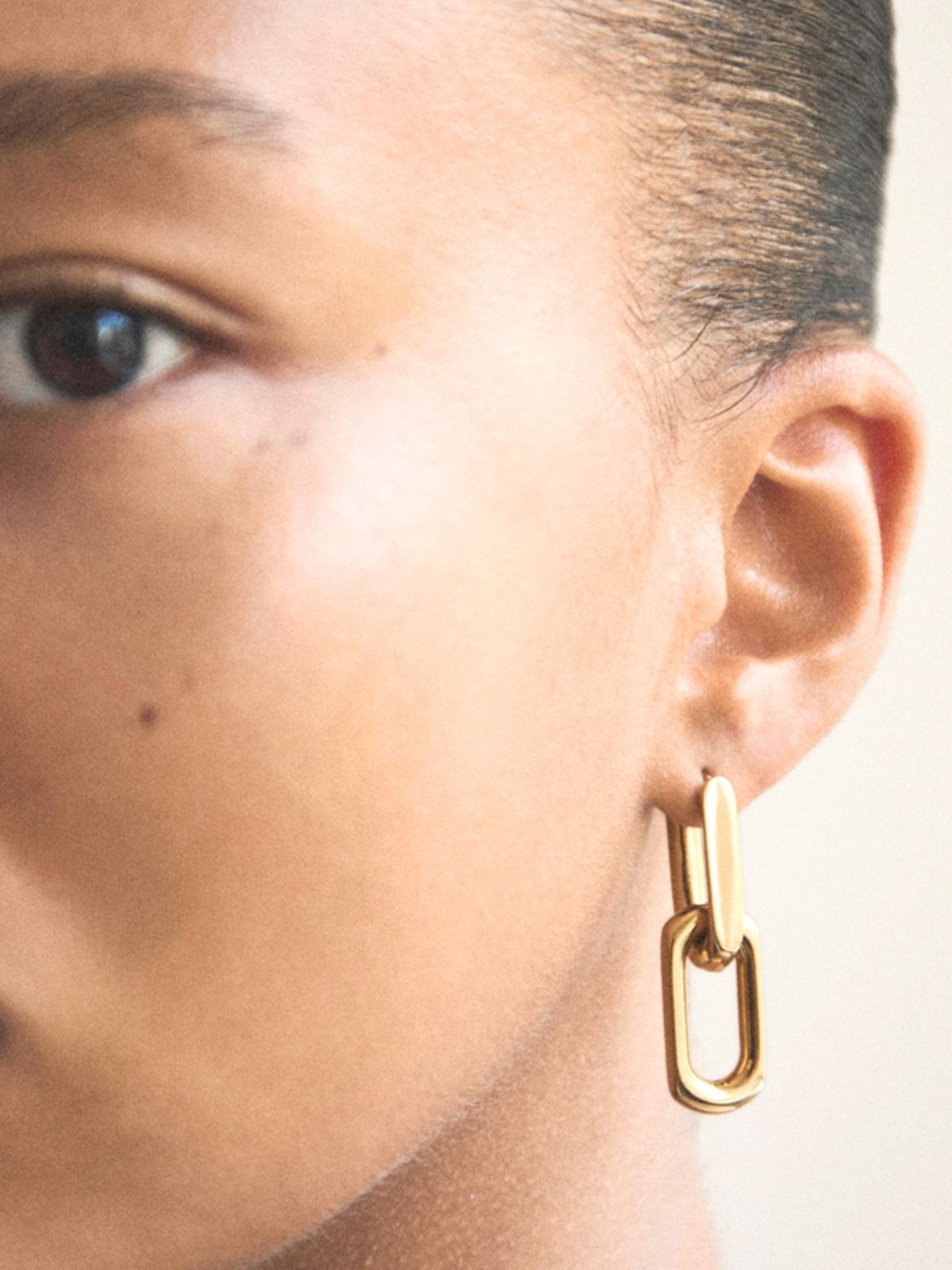 Model mit goldfarbenem Statement-Ohrring von COPENHAGEN STUDIOS im modernen skandinavischen Design