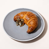 COPENHAGEN STUDIOS Puffy Heart Ohrstecker neben einem frischen Croissant