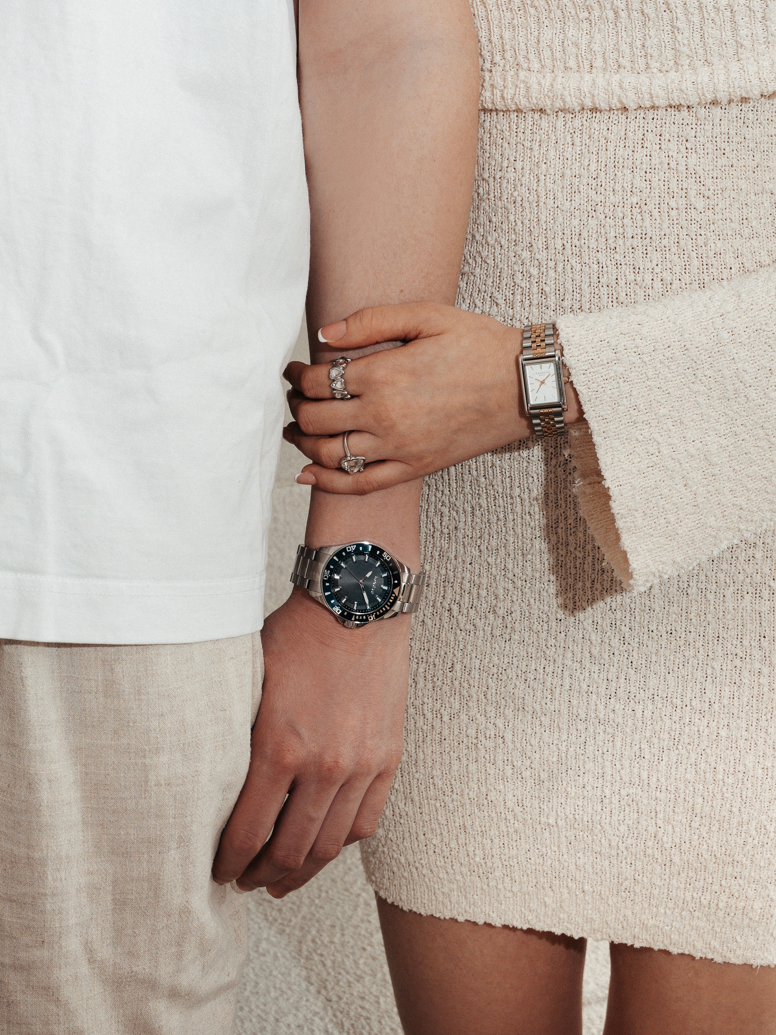 Paar trägt LIEBESKIND BERLIN & s.Oliver Armbanduhren und Ringe – elegante Damen- und Herrenuhr kombiniert mit modernem Schmuck, stilvoller Couple-Look.