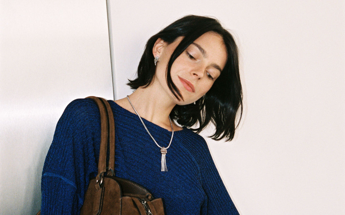 LIEBESKIND BERLIN Halskette mit langem Fringe Anhänger in Silber am Model mit blauem Pullover