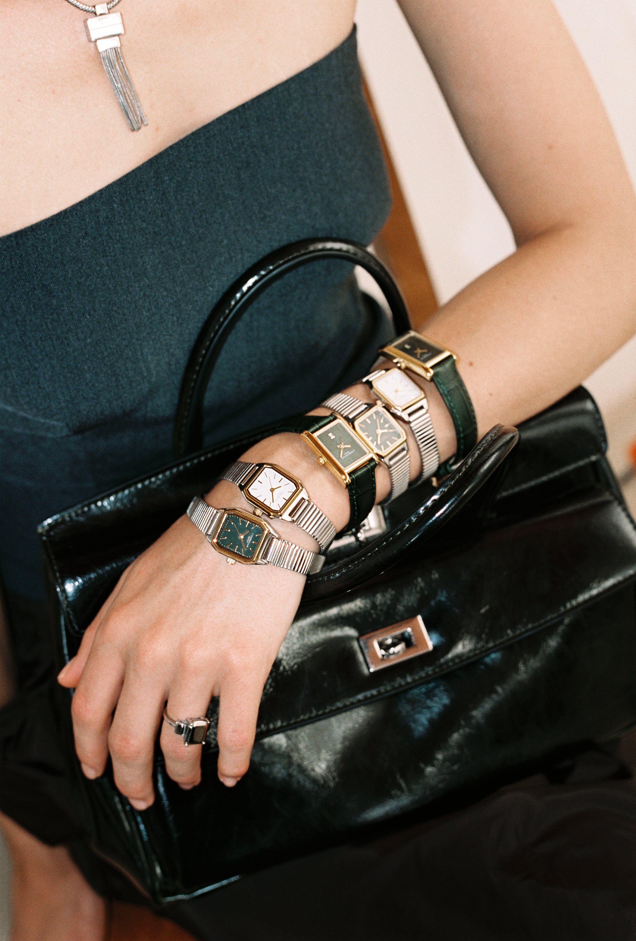Model trägt mehrere LIEBESKIND BERLIN Uhren mit Metallarmband sowie silberne Statement-Halskette