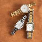 Drei elegante s.Oliver Damenarmbanduhren in Gold, Silber und Bicolor mit unterschiedlichen Gehäuseformen, hellen Zifferblättern und Metallarmbändern auf warmem, cognacbraunem Lederhintergrund.