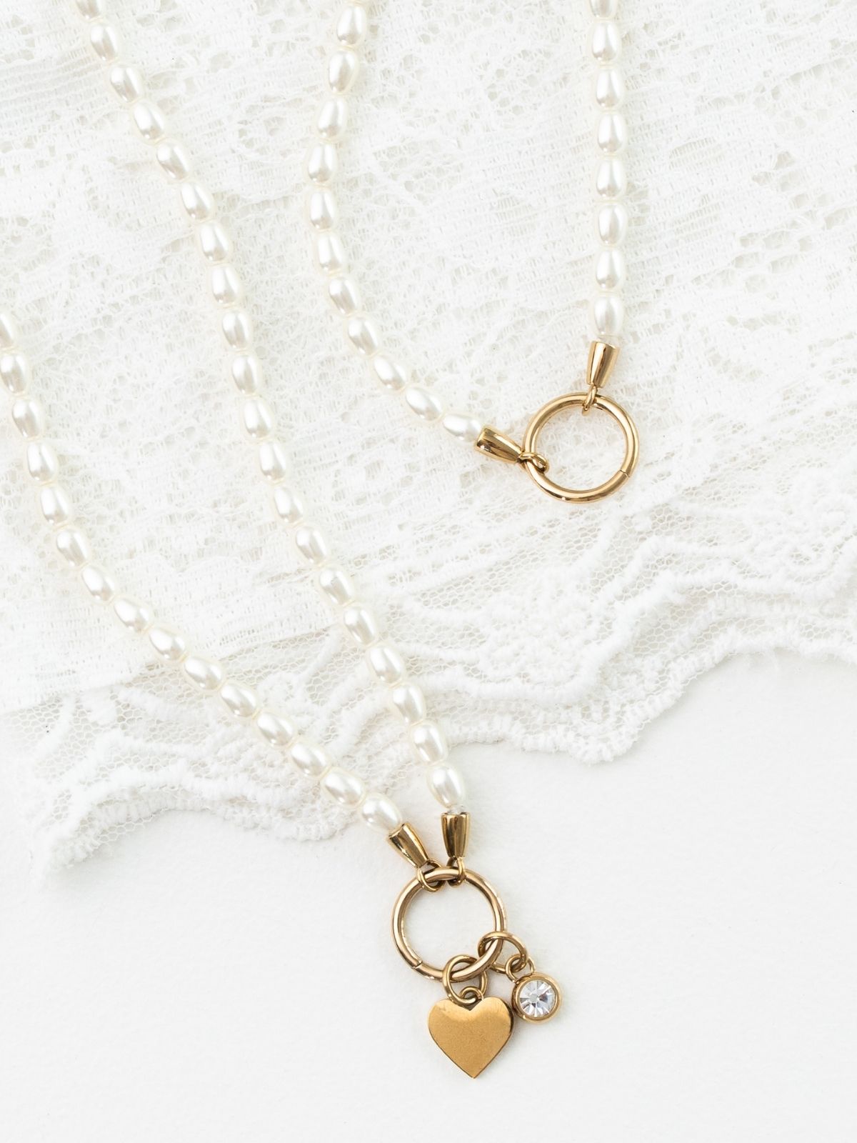 Elegante Perlenketten mit goldfarbenen Verschlüssen und Herzanhänger mit Zirkonia auf feiner Spitze – zeitloser Hochzeitsschmuck für Braut und besondere Anlässe.