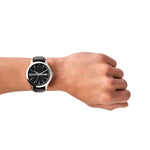 Armani Exchange Armbanduhr mit schwarzem Zifferblatt mit silbernen Verzierungen, Datumanzeige, silbernem Gehäuse und schwarzem Lederband; Tragebild