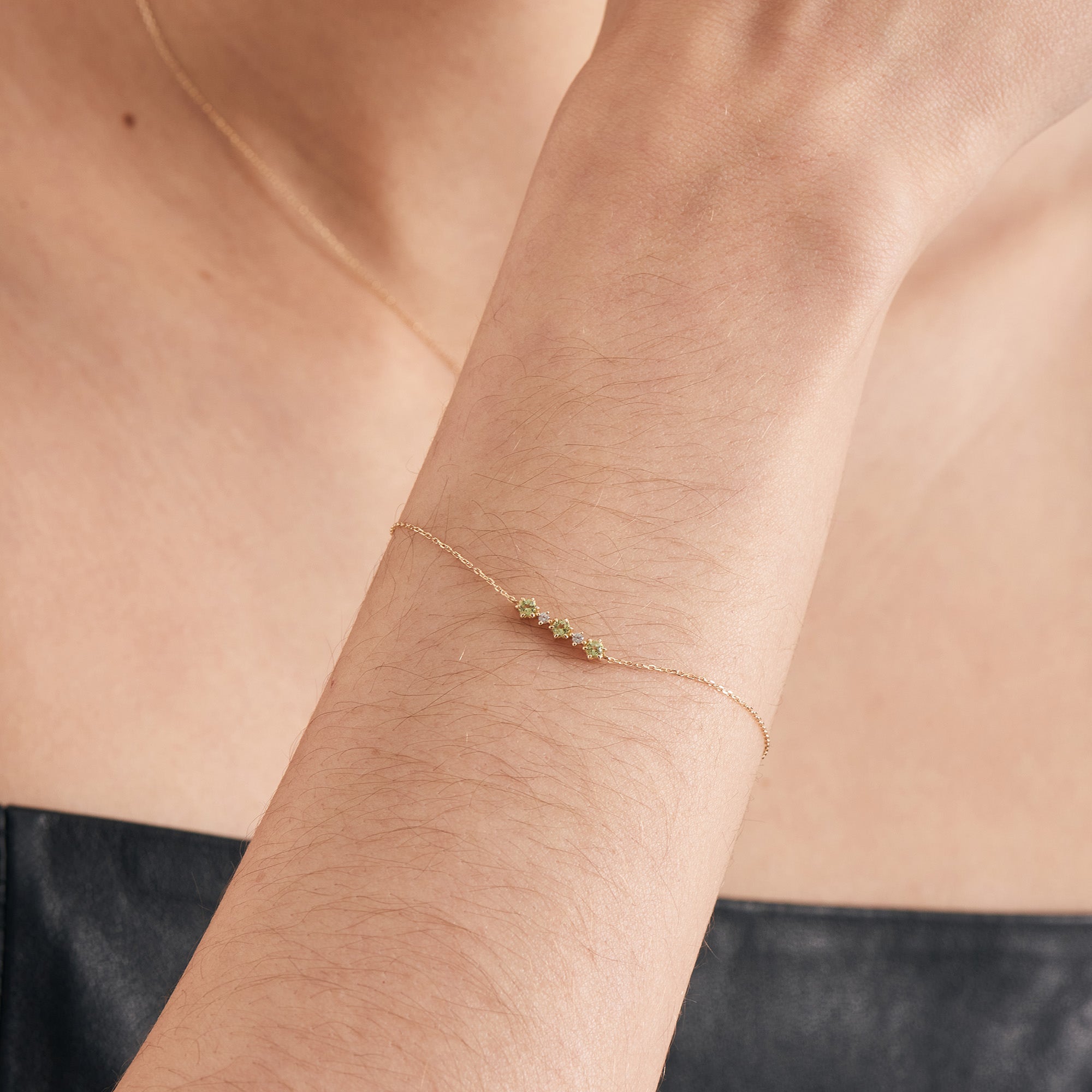 Ania Haie Armband bestehend aus einer feinen goldenen Kette mit drei grünen Peridot-Steinen und zwei weißen Saphiren; Tragebild