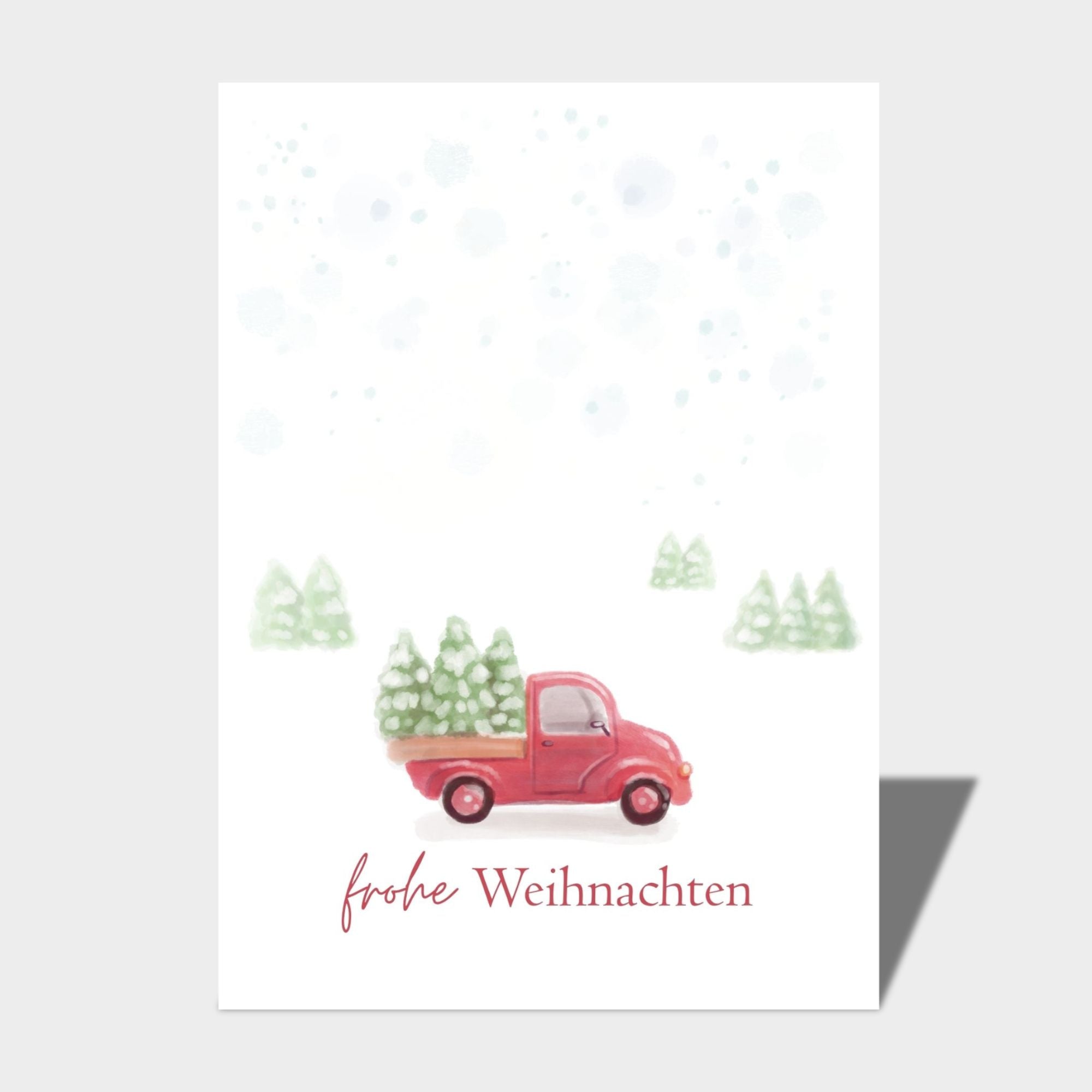 Die "Postkarte - Frohe Weihnachten DIN A6" von Cool | Time zeigt einen roten Lastwagen mit Weihnachtsbäumen in einer verschneiten Landschaft, darunter der Text "Frohe Weihnachten".