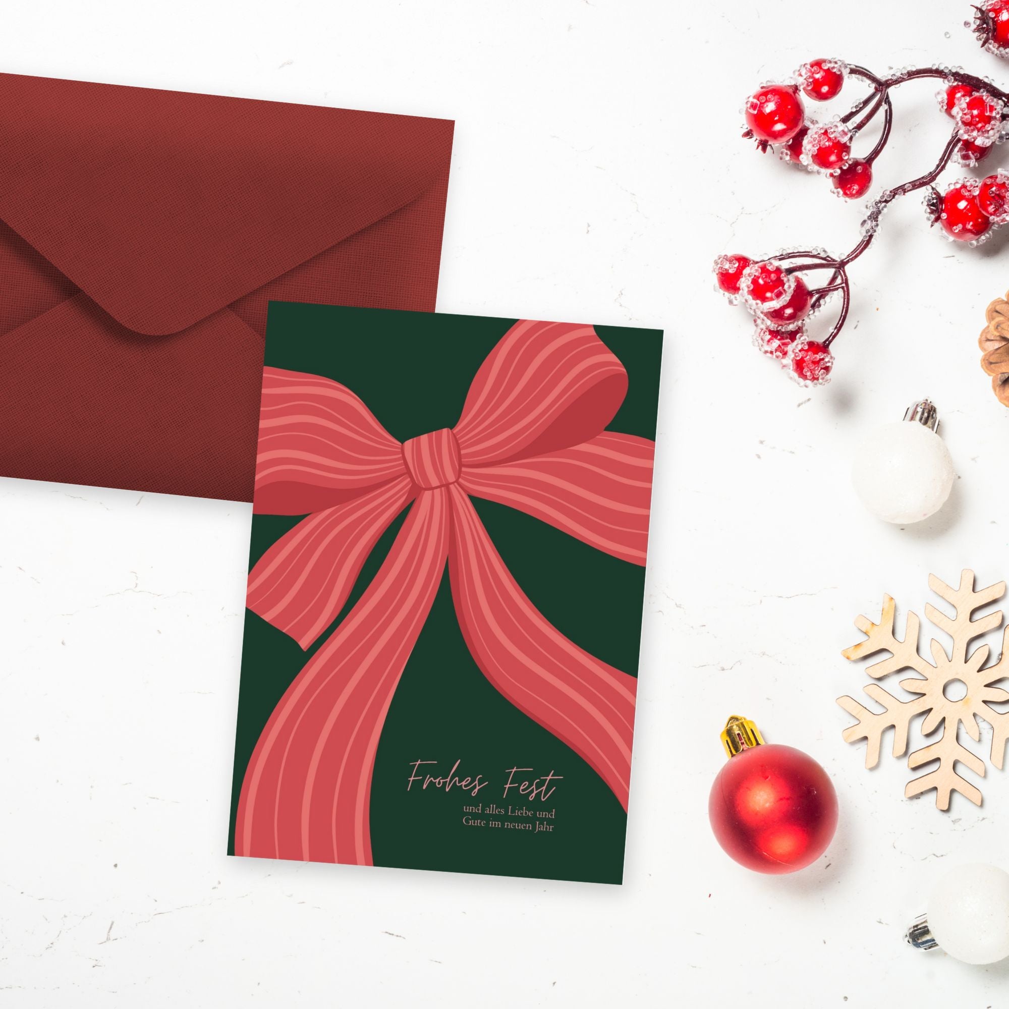 Postkarte in A6 mit süßem Weihnachtsmotiv - Eine große rote Schleife auf grünem Untergrund mit dem Text "Frohes Fest und alles Liebe und Gute im neuen Jahr"