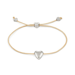 Das COPENHAGEN STUDIOS Armband - Balloon Hearts von Copenhagen Studios ist mit einer cremefarbenen Kordel, einem silbernen Herzanhänger und verstellbaren herzförmigen Verschlüssen ausgestattet und verbindet einen verspielten, von Ballons inspirierten Stil mit moderner Eleganz.