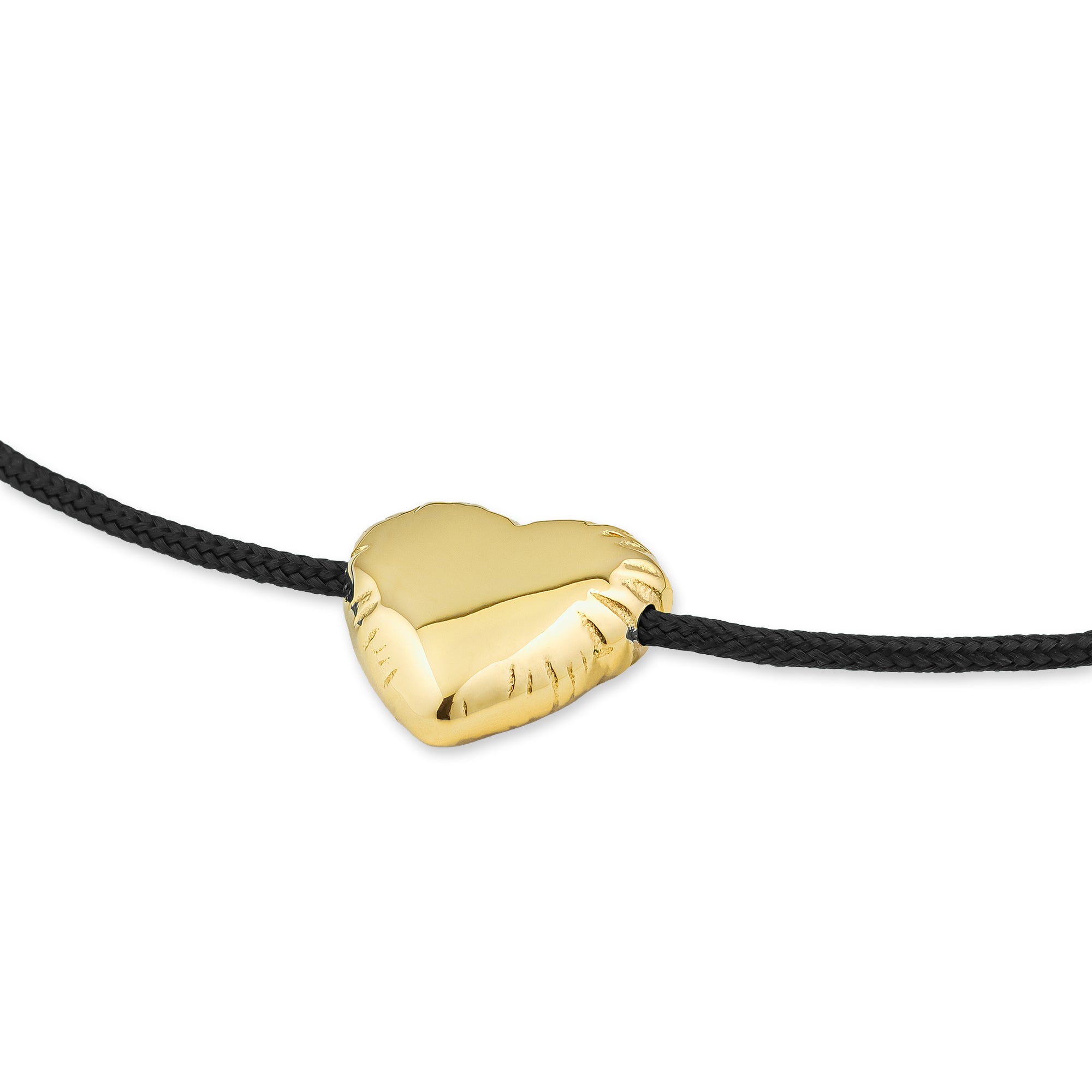 Das COPENHAGEN STUDIOS Armband - Balloon Hearts von Copenhagen Studios zeigt einen goldenen herzförmigen Anhänger an einer schwarzen Kordel vor einem weißen Hintergrund.
