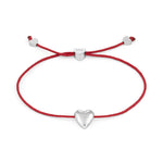 Das COPENHAGEN STUDIOS Armband - Balloon Hearts von Copenhagen Studios besteht aus einer roten Schnur mit einem silbernen Herzanhänger und herzförmigen Silberakzenten an den Enden.