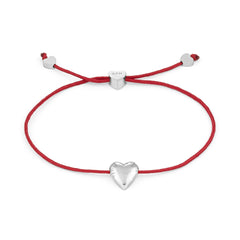 Das COPENHAGEN STUDIOS Armband - Balloon Hearts von Copenhagen Studios besteht aus einer roten Schnur mit einem silbernen Herzanhänger und herzförmigen Silberakzenten an den Enden.