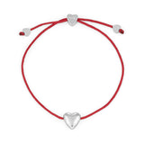 Das Armband COPENHAGEN STUDIOS - Balloon Hearts von Copenhagen Studios besteht aus einem roten Band mit drei zarten silbernen Herzanhängern - einem in der Mitte und zwei an den verstellbaren Enden.