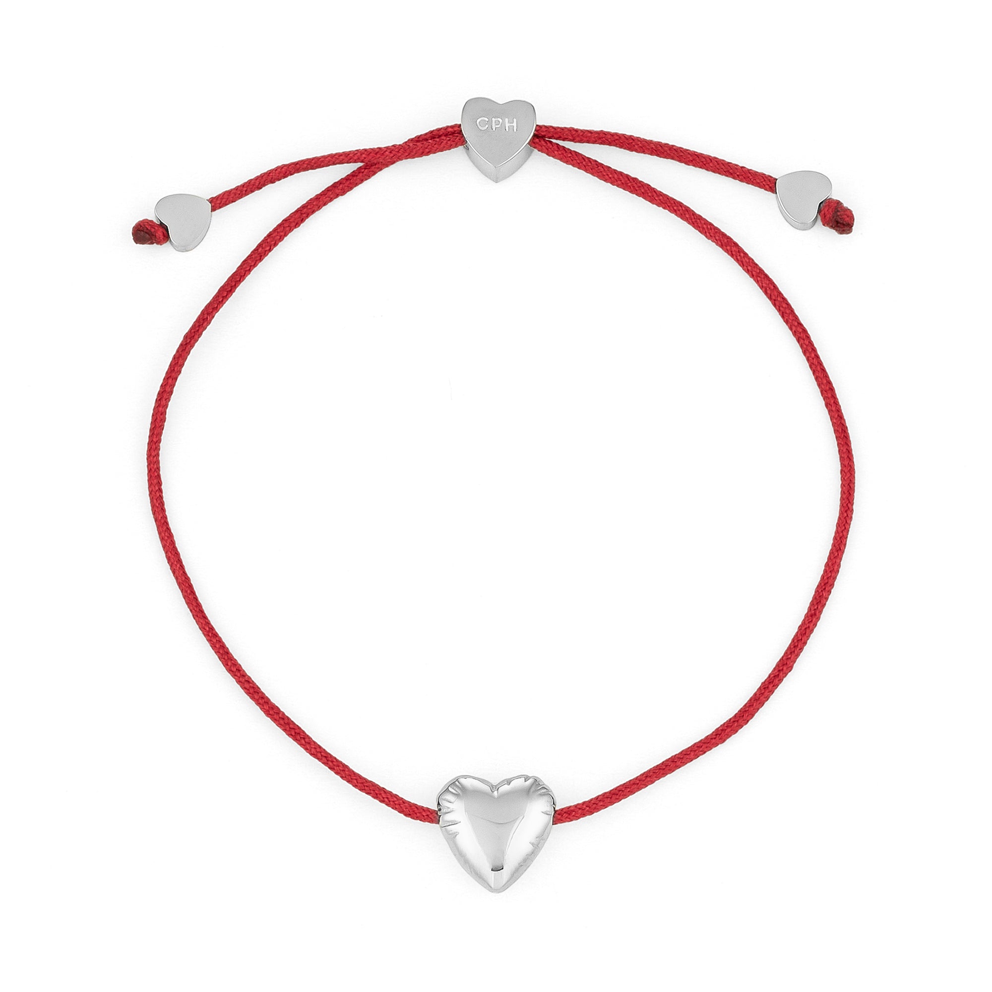 Das Armband COPENHAGEN STUDIOS - Balloon Hearts von Copenhagen Studios besteht aus einem roten Band mit drei zarten silbernen Herzanhängern - einem in der Mitte und zwei an den verstellbaren Enden.