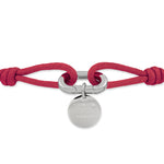 Rotes Gliederarmband aus Stoff mit einem runden silbernen Anhänger und Verschluss, graviert mit "Copenhagen Studios". Produkt: COPENHAGEN STUDIOS Armband - Fabric Link von Copenhagen Studios.