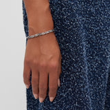 Eine mit dem COPENHAGEN STUDIOS Armband - Edgy Bracelet von Copenhagen Studios geschmückte Hand ruht auf einem strukturierten marineblauen Stoff.