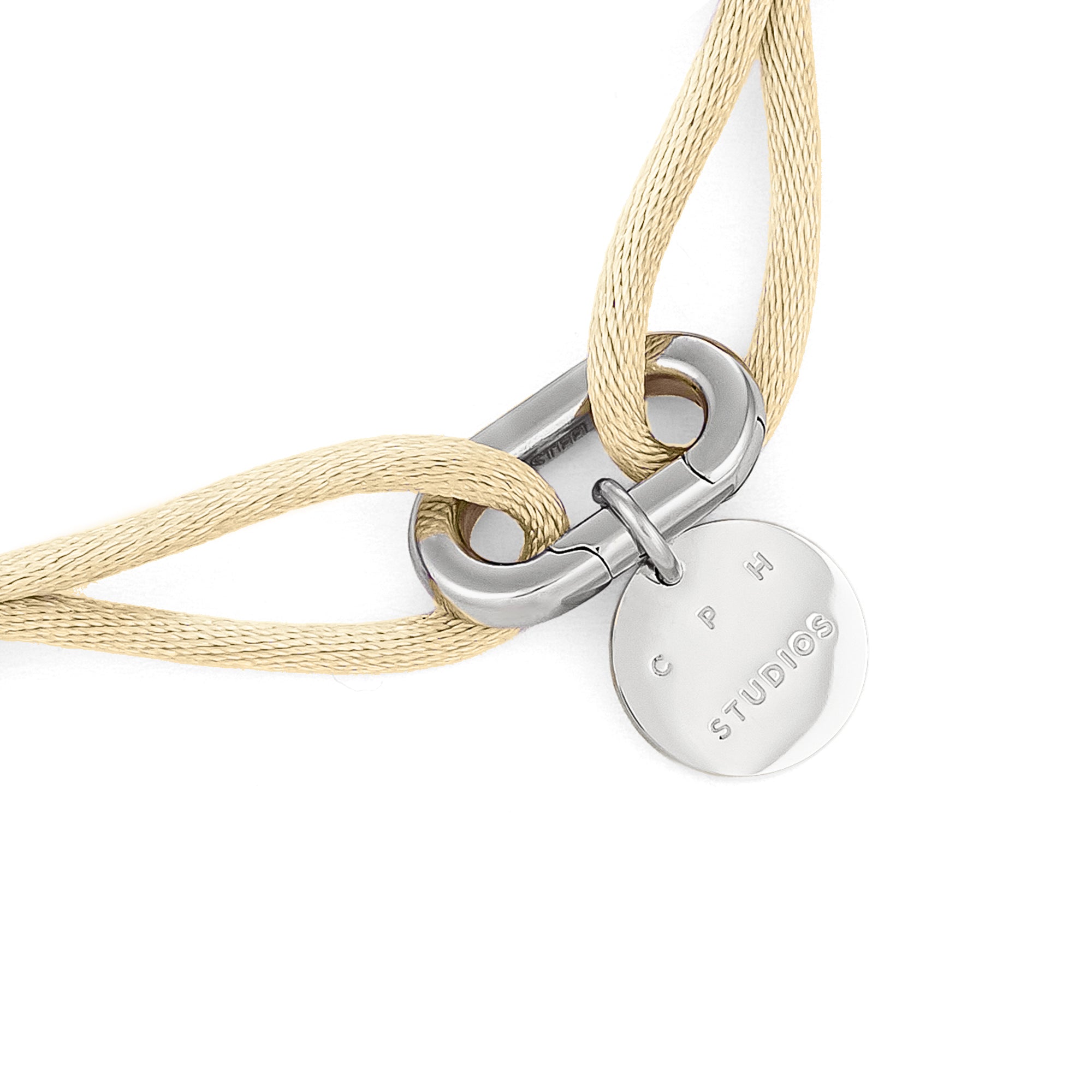 Beigefarbene Kordelkette mit silbernem Verschluss und rundem Anhänger mit COPENHAGEN STUDIOS-Gravur. Ideal zum Kombinieren mit dem COPENHAGEN STUDIOS Armband - Fabric Link von Copenhagen Studios für einen stilvollen Lagenlook.