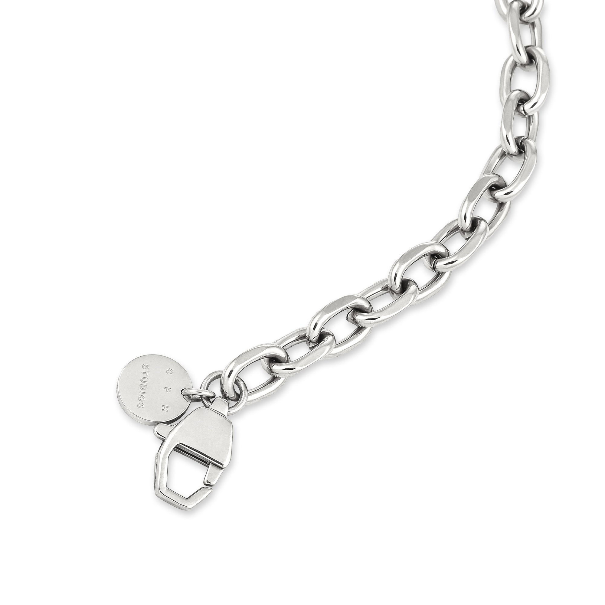 Die COPENHAGEN STUDIOS Halskette - Basic Chains von Copenhagen Studios zeichnet sich durch ovale Glieder, einen runden Anhänger und einen geometrischen Verschluss aus - die perfekte klobige Halskette, die jeden Look aufwertet. Sie wird auf einem strahlend weißen Hintergrund präsentiert.