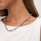 Eine Frau kombiniert ein weißes ärmelloses Top mit der COPENHAGEN STUDIOS Halskette - Basic Chains, einer klobigen Silberkette von Copenhagen Studios.