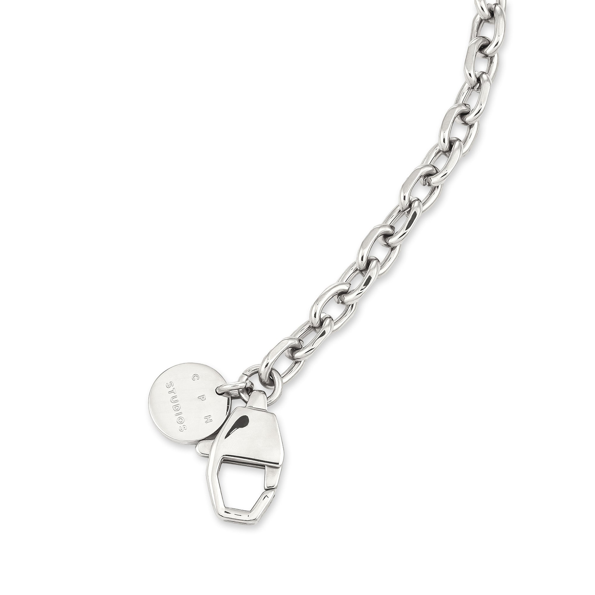 Das COPENHAGEN STUDIOS Armband - Basic Chains von Copenhagen Studios zeichnet sich durch eine auffällige Silberkette, einen runden Anhänger und einen geometrischen Vorhängeschloss-Charme aus - das perfekte Statement-Armband für jeden Stil.