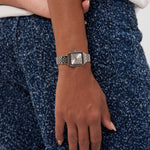 Sie tragen die COPENHAGEN STUDIOS Armbanduhr - Vintage Watch von Copenhagen Studios mit einem silbernen Band und einer blau gesprenkelten Hose und verkörpern damit zeitlosen Stil und modernes Flair.