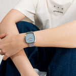 COPENHAGEN STUDIOS Curvy Leather Watch in Hellblau und Silber am Handgelenk getragen im minimalistischen Look