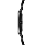 Seitenansicht der Tamaris Armbanduhr - The Black Glamorous, die ein schwarzes, rundes Zifferblatt und ein schmales Edelstahlband vor einem weißen Hintergrund zeigt.