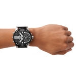 Diesel Armbanduhr mit schwarzem Zifferblatt mit mehreren Chronographen, Zeitzonenanzeigen und silbernen Verzierungen, silbernem Gehäuse mit schwarzem Topring und schwarzem Lederband; Tragebild