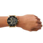 Diesel Armbanduhr mit schwarzem Zifferblatt mit mehreren Chronographen und Zeitzonenanzeigen, goldenem Gehäuse und goldenem Edelstahlband; Tragebild