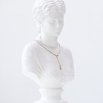 Weiße Marmorbüste einer Frau präsentiert die Echtzeit Halskette - The Sleek One von Echtzeit, eine goldene Halskette, die sich ideal für den trendigen Layering-Look eignet, vor einem schlichten weißen Hintergrund.