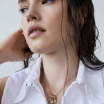Frau mit nassem Haar, weißem Hemd mit Kragen und einem zeitlosen Accessoire: die Echtzeit Halskette - Like Diamonds by Echtzeit, eine elegante Halskette mit einem stilvollen Tropfenanhänger.