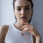 A woman in einem weißen, ärmellosen Top präsentiert die Echtzeit Halskette - Like Diamonds samt passender Ohrringe von Echtzeit - ein zeitloses Accessoire für jeden Anlass.
